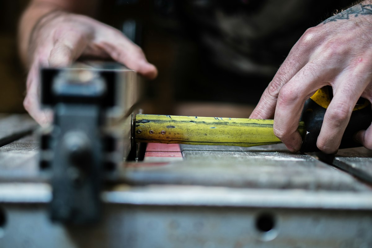 Hands measuring wood in a workshop